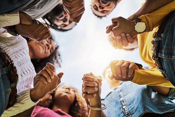 Shot of a group of friends holding hands